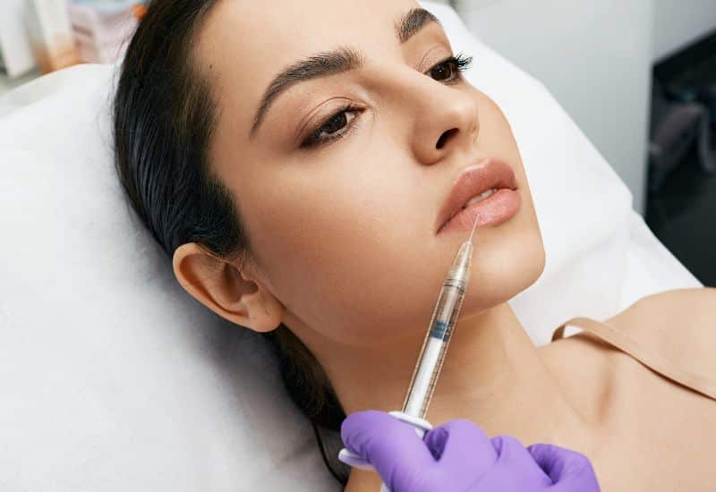 How is lip lesion removal surgery performed